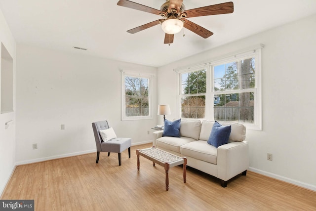 sitting room with light wood-style flooring, baseboards, visible vents, and ceiling fan