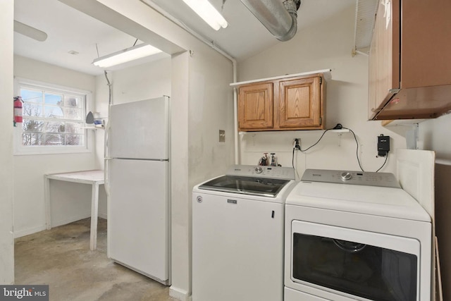 clothes washing area featuring cabinet space and washing machine and clothes dryer