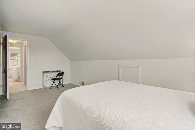 carpeted bedroom with lofted ceiling and visible vents