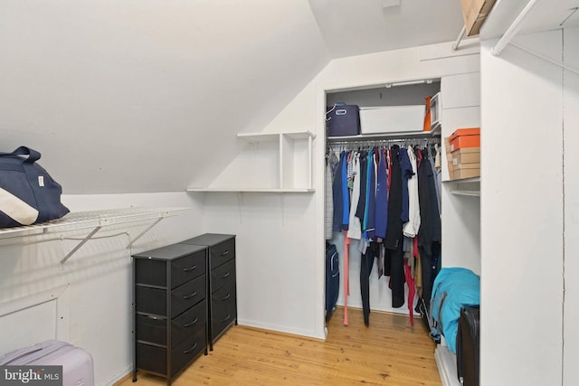 walk in closet with lofted ceiling and light wood-style floors