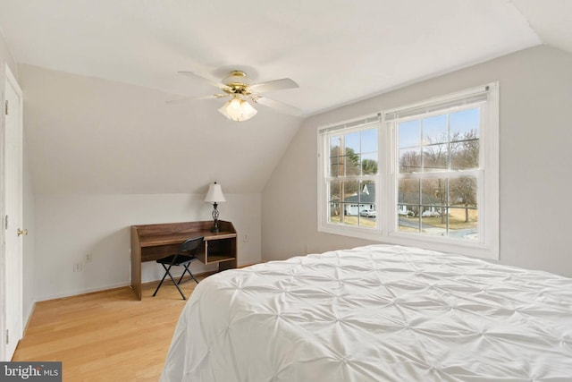 bedroom featuring lofted ceiling, light wood-style flooring, a ceiling fan, and baseboards