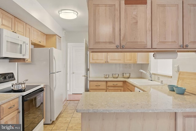 kitchen with white microwave, range with electric cooktop, light brown cabinetry, decorative backsplash, and a sink