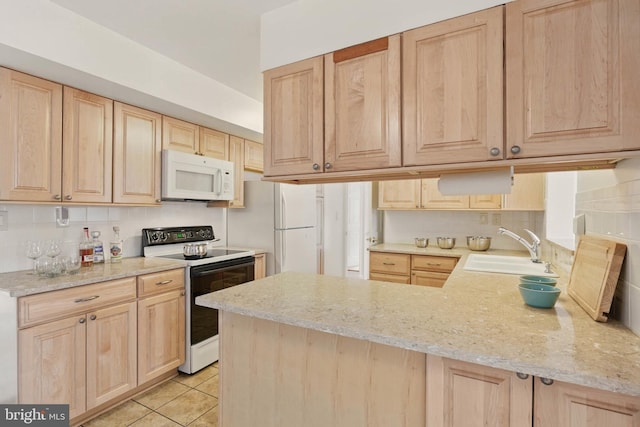 kitchen with tasteful backsplash, light brown cabinets, a peninsula, white appliances, and a sink