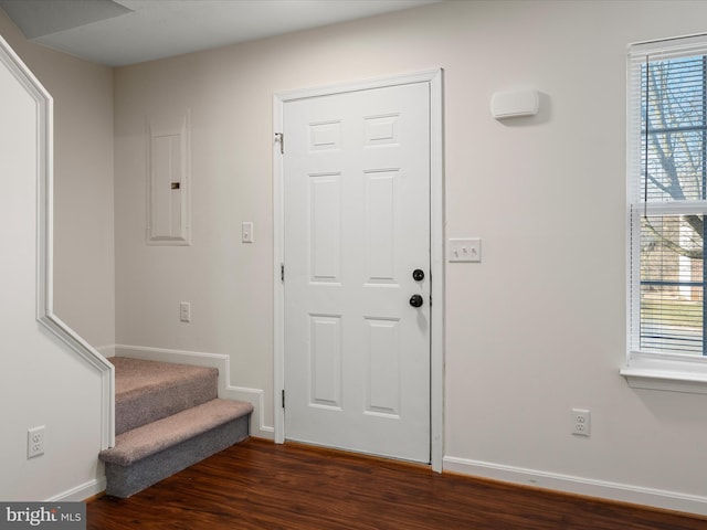 foyer entrance featuring electric panel, stairway, baseboards, and dark wood-style flooring