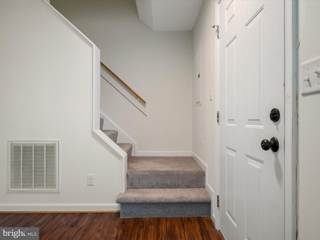 staircase featuring visible vents, baseboards, and wood finished floors