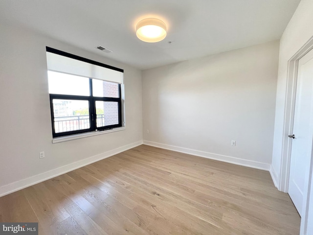 unfurnished room with visible vents, baseboards, and light wood-type flooring