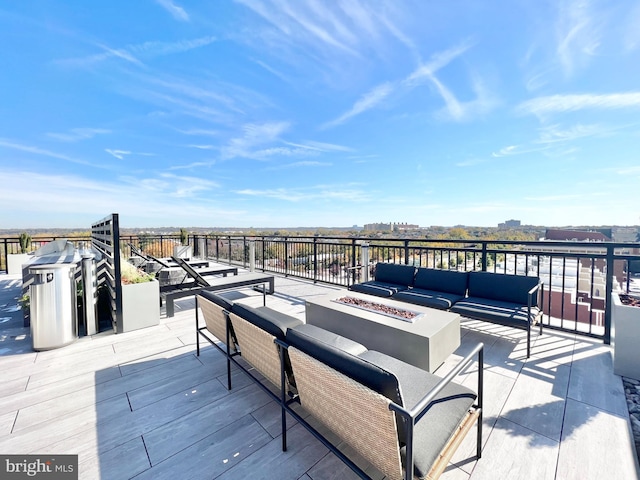 wooden terrace featuring an outdoor living space with a fire pit