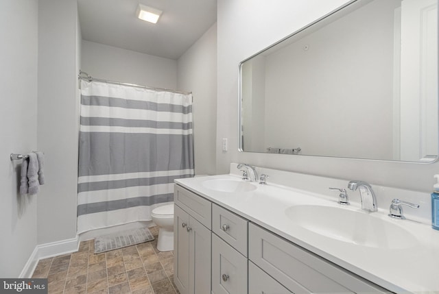 bathroom with double vanity, toilet, a shower with shower curtain, and a sink