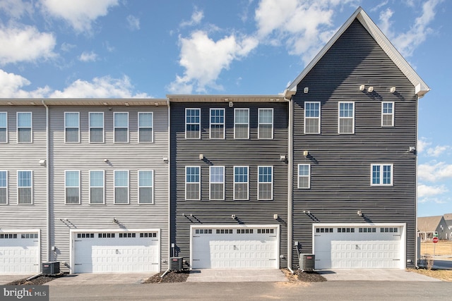 back of property with central air condition unit and an attached garage