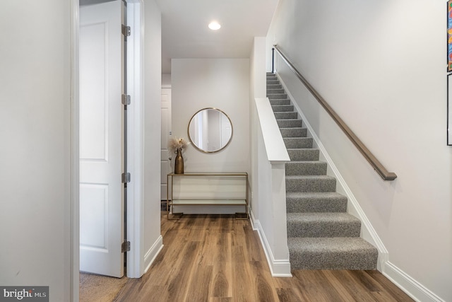 stairs featuring recessed lighting, wood finished floors, and baseboards