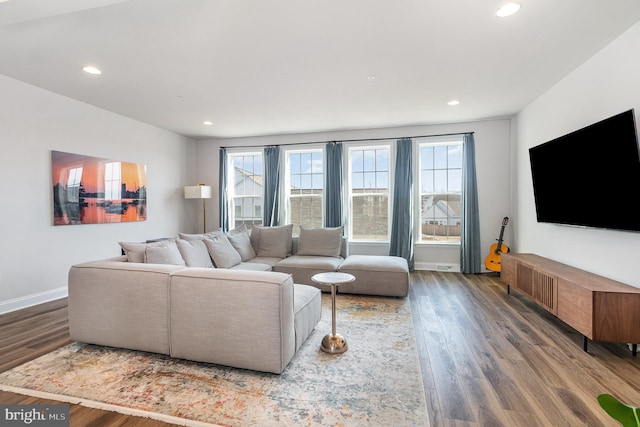 living room featuring recessed lighting, baseboards, a healthy amount of sunlight, and wood finished floors