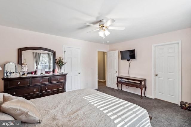 bedroom with a ceiling fan, baseboards, and dark colored carpet