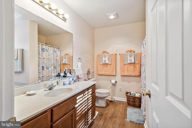 bathroom featuring vanity, toilet, and wood finished floors