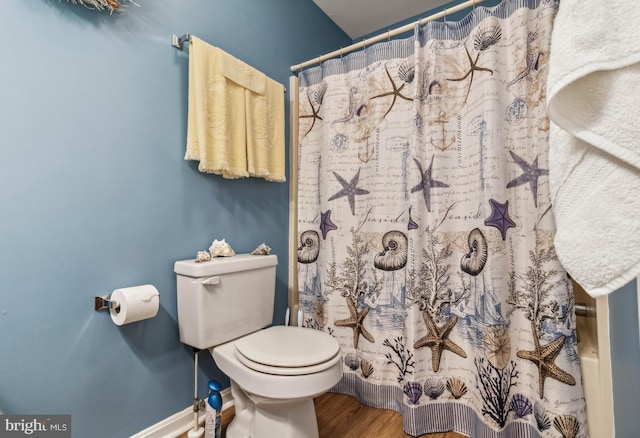 full bathroom featuring a shower with curtain, baseboards, toilet, and wood finished floors