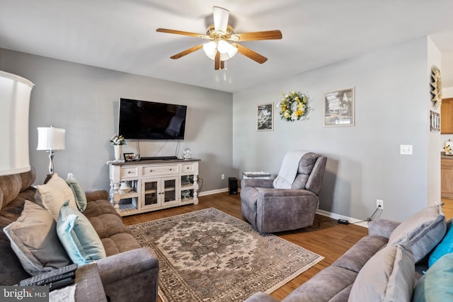 living room with wood finished floors, baseboards, and ceiling fan