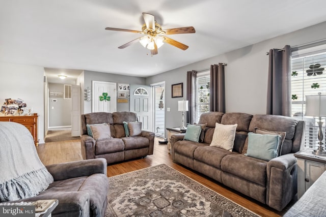 living area featuring light wood-style flooring and ceiling fan