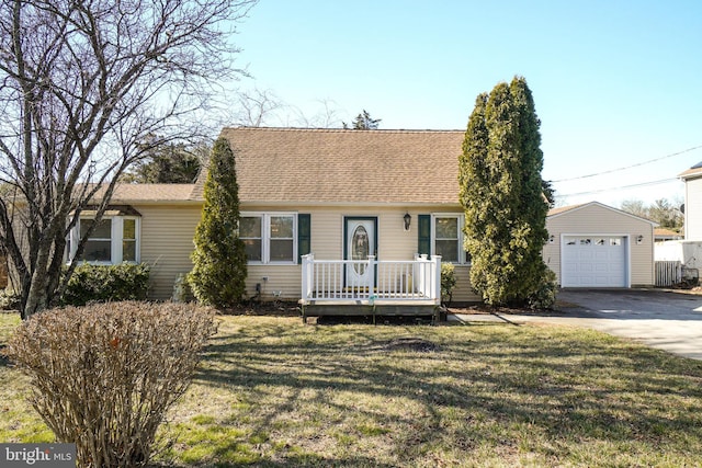 view of front of home featuring an outbuilding, a front lawn, concrete driveway, a shingled roof, and a garage