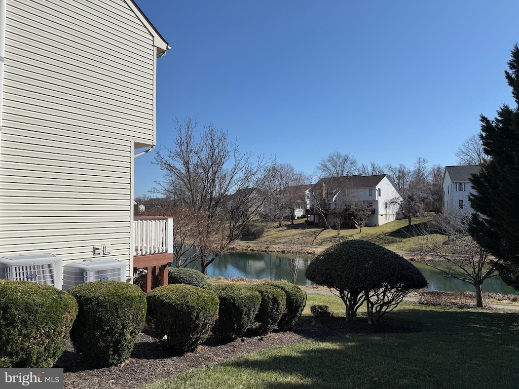 view of yard with a water view and central AC