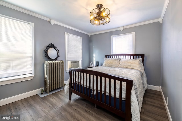 bedroom featuring radiator, wood finished floors, baseboards, and ornamental molding