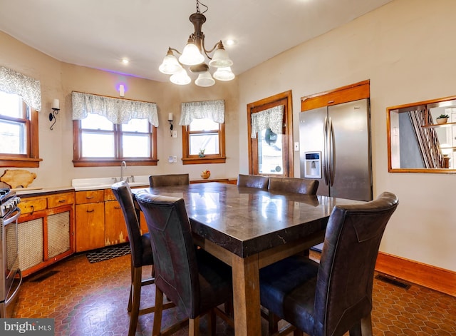 dining room with an inviting chandelier, baseboards, and visible vents