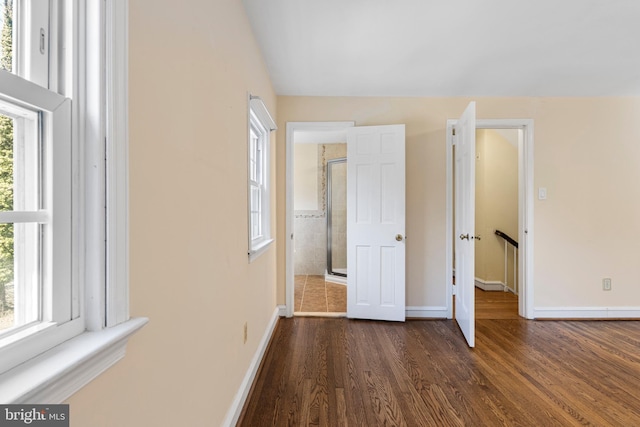 unfurnished bedroom featuring baseboards and dark wood-style flooring