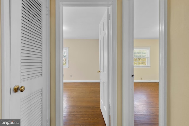 hallway with baseboards and wood finished floors