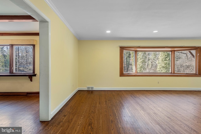 spare room with wood finished floors, visible vents, baseboards, recessed lighting, and ornamental molding