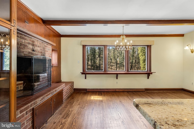 interior space with beamed ceiling, baseboards, an inviting chandelier, and wood finished floors