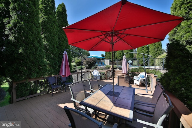 wooden deck featuring outdoor dining space and fence