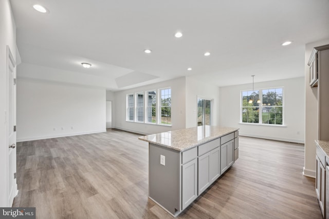 kitchen with recessed lighting, a kitchen island, and light wood finished floors