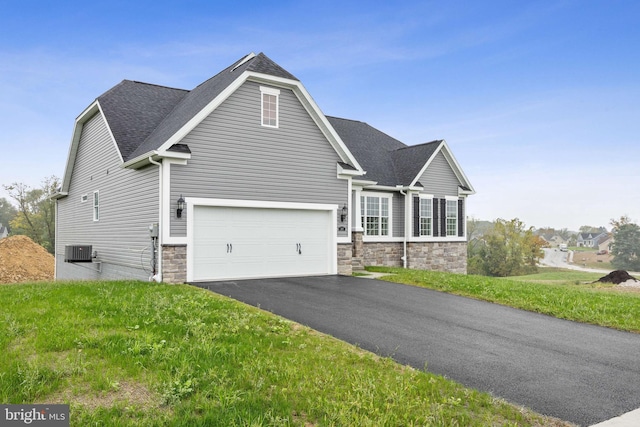 view of front of house featuring stone siding, cooling unit, driveway, and roof with shingles