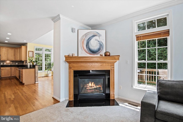 interior space with visible vents, a fireplace with flush hearth, crown molding, decorative backsplash, and baseboards