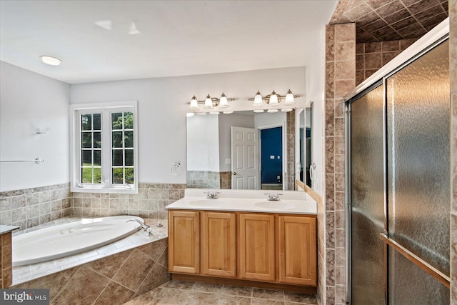 bathroom with a bath, a stall shower, double vanity, and a sink