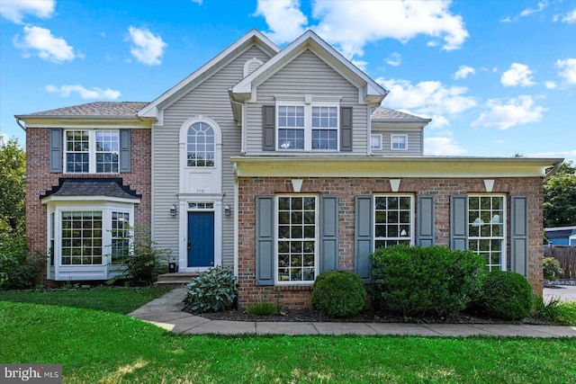 view of front of home with brick siding and a front yard