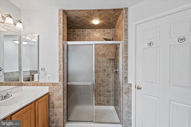 full bath featuring a stall shower, vanity, and tile walls