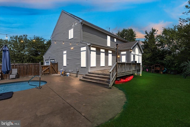 back of house with fence, a yard, a deck, a patio, and a gate