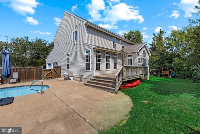 rear view of house with a lawn, a patio, fence, a playground, and a wooden deck