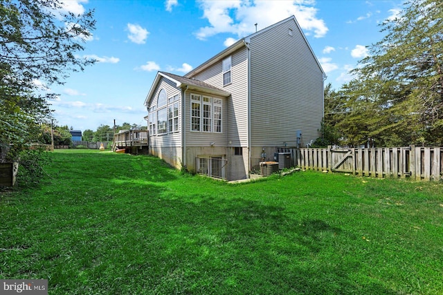 view of home's exterior with a deck, central AC, a yard, and fence