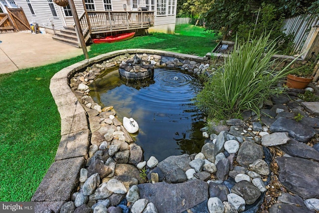 exterior space with a garden pond and fence