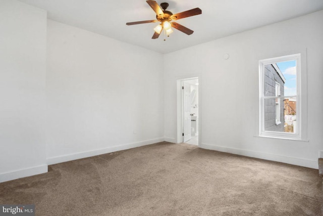 empty room featuring baseboards, carpet floors, and a ceiling fan