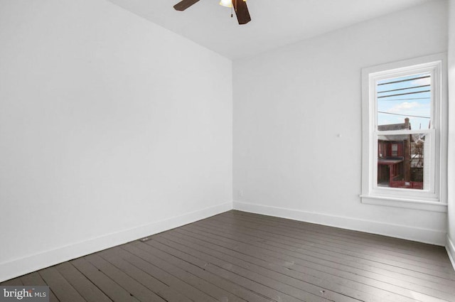 unfurnished room with dark wood-type flooring and baseboards