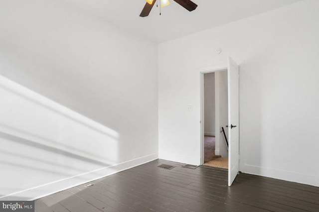 unfurnished room featuring dark wood finished floors, baseboards, visible vents, and ceiling fan