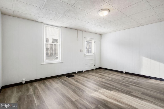 unfurnished room featuring visible vents, baseboards, and wood finished floors