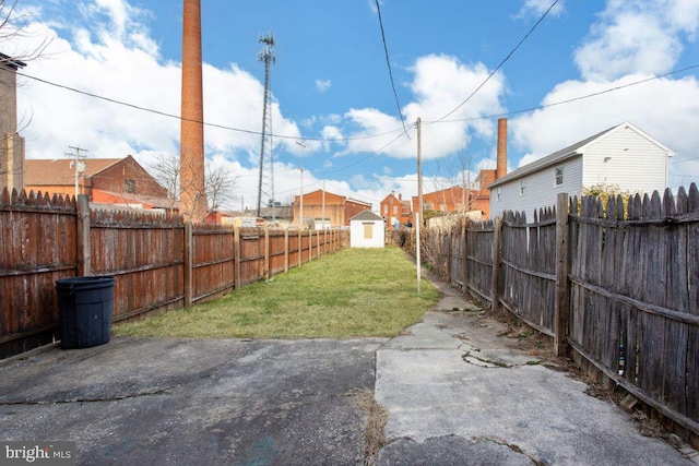 view of yard featuring an outdoor structure, a storage unit, and a fenced backyard