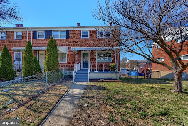 view of property with a front lawn, a gate, a fenced front yard, brick siding, and a chimney