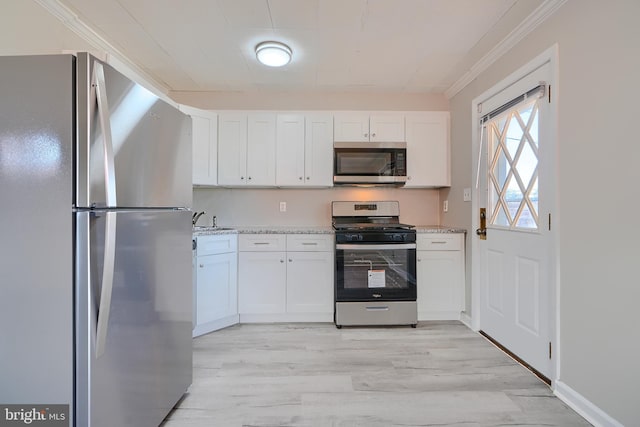 kitchen featuring light wood-style floors, appliances with stainless steel finishes, white cabinets, and crown molding