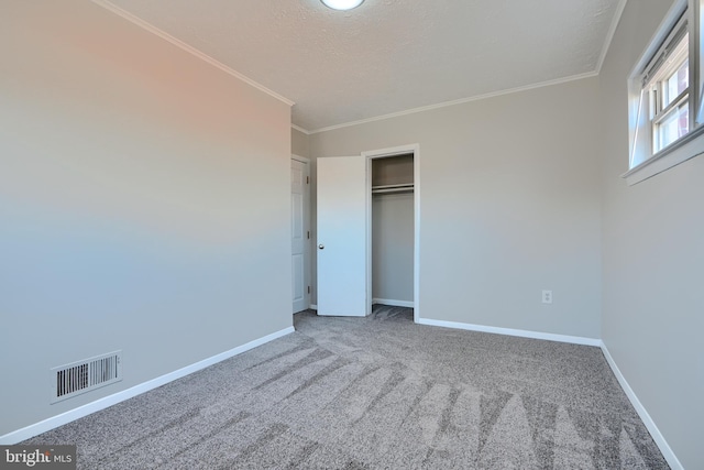 unfurnished bedroom with carpet, baseboards, visible vents, a closet, and crown molding