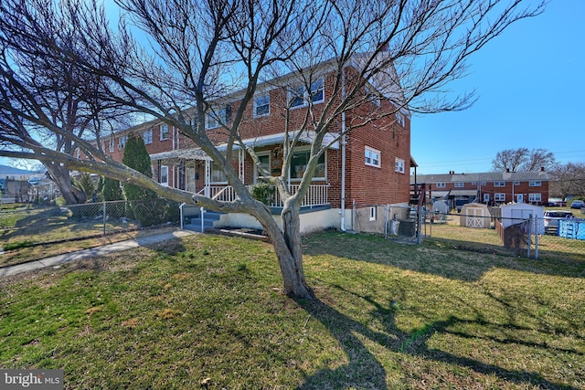 exterior space with brick siding, fence, and a lawn