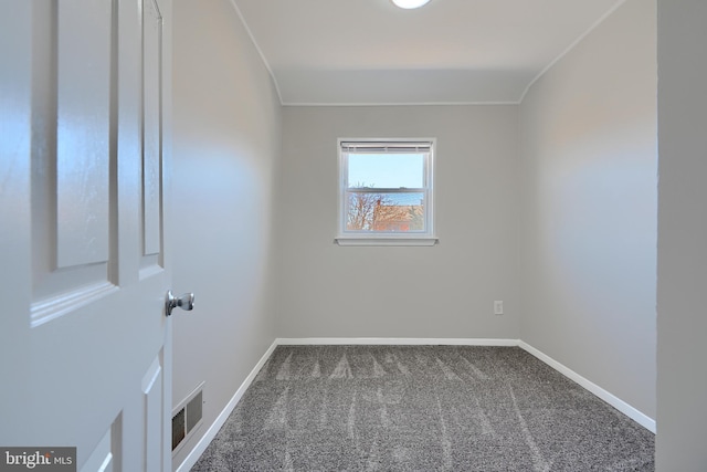 spare room with crown molding, carpet flooring, baseboards, and visible vents