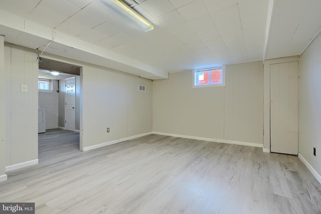 below grade area featuring visible vents, baseboards, and light wood finished floors